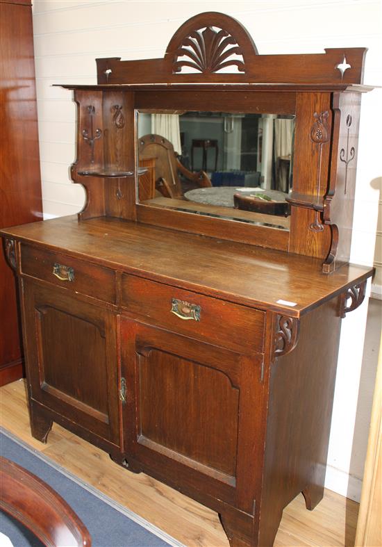 An Edwardian Maple & Co oak chiffonier, with mirrored back, two drawers and two panelled doors, W.137cm D.51cm H.175cm